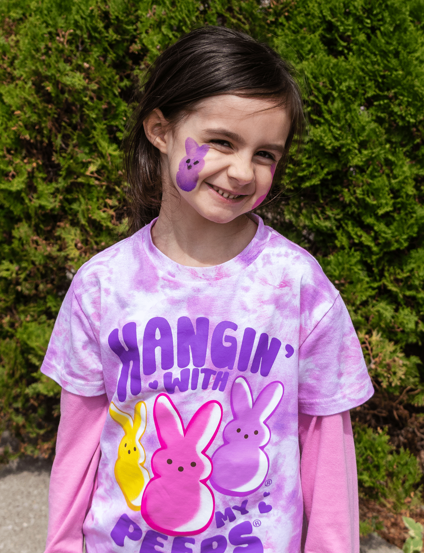Smiling girl outdoors, “Hangin’ with my Peeps” shirt and Peep art on her cheek—joyful, welcoming church community. - Muscatine Church of Christ