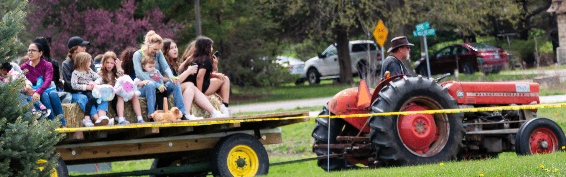 Children and adults enjoy a joyful hayride together, surrounded by trees—a warm welcome to all in our church family. - Muscatine Church of Christ