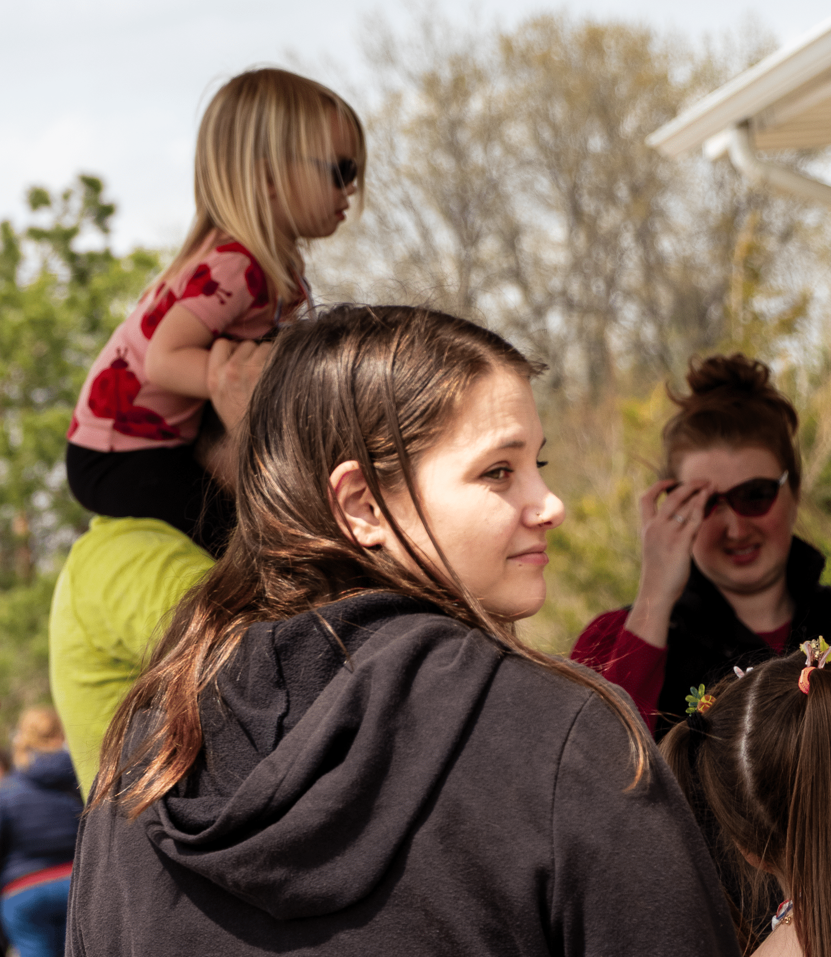 A woman and friends share a joyful moment outdoors, reminding us of community, welcome, and hope at Muscatine Church. - Muscatine Church of Christ