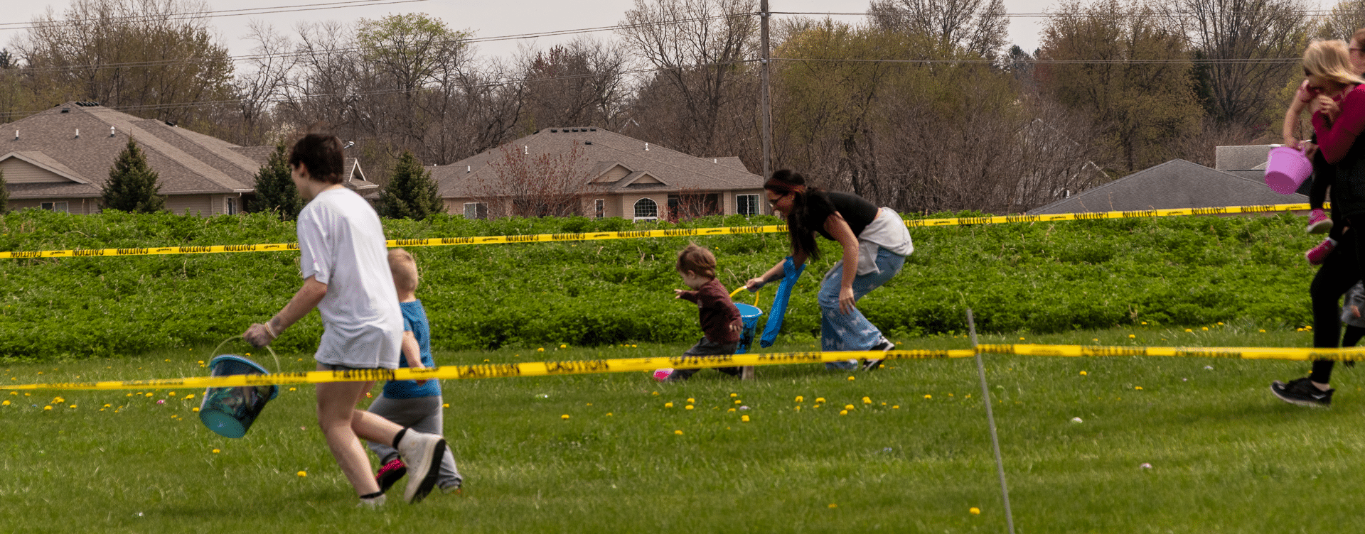Families and friends gather outdoors, smiling and searching for treats—everyone is welcome to join the fun and hope!. - Muscatine Church of Christ