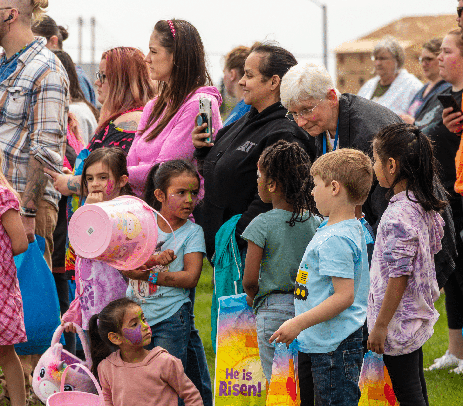 Smiling kids with Easter baskets gather outside, joined by caring adults—celebrating hope and togetherness. - Muscatine Church of Christ