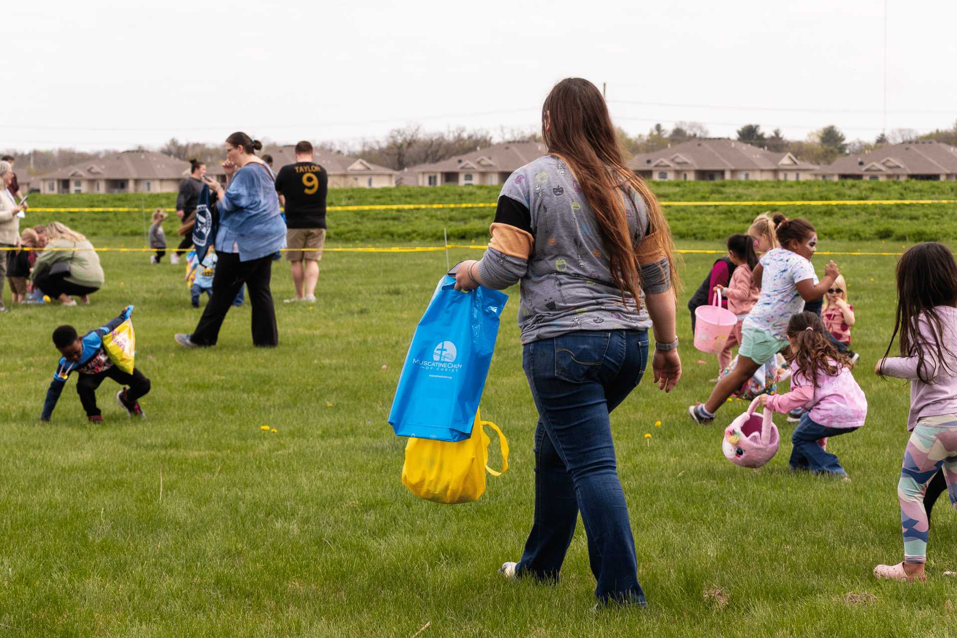 Families and children gather on the church lawn for a joyful egg hunt, sharing smiles, laughter, and hope together. - Muscatine Church of Christ