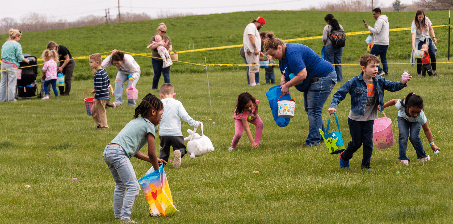 Children joyfully hunt for Easter eggs, filling baskets as our church family looks on with warm smiles and open hearts. - Muscatine Church of Christ