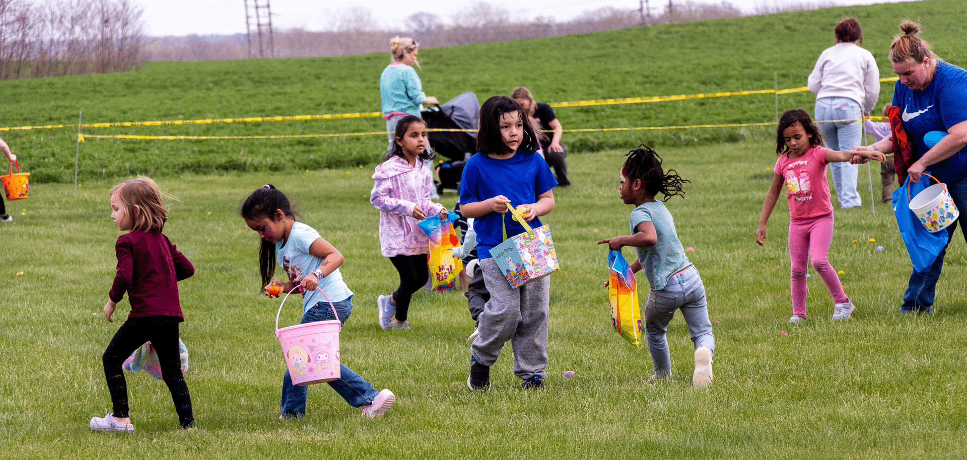 Children with bright baskets enjoy a joyful egg hunt on the grass, warmly welcomed by our caring church family. - Muscatine Church of Christ