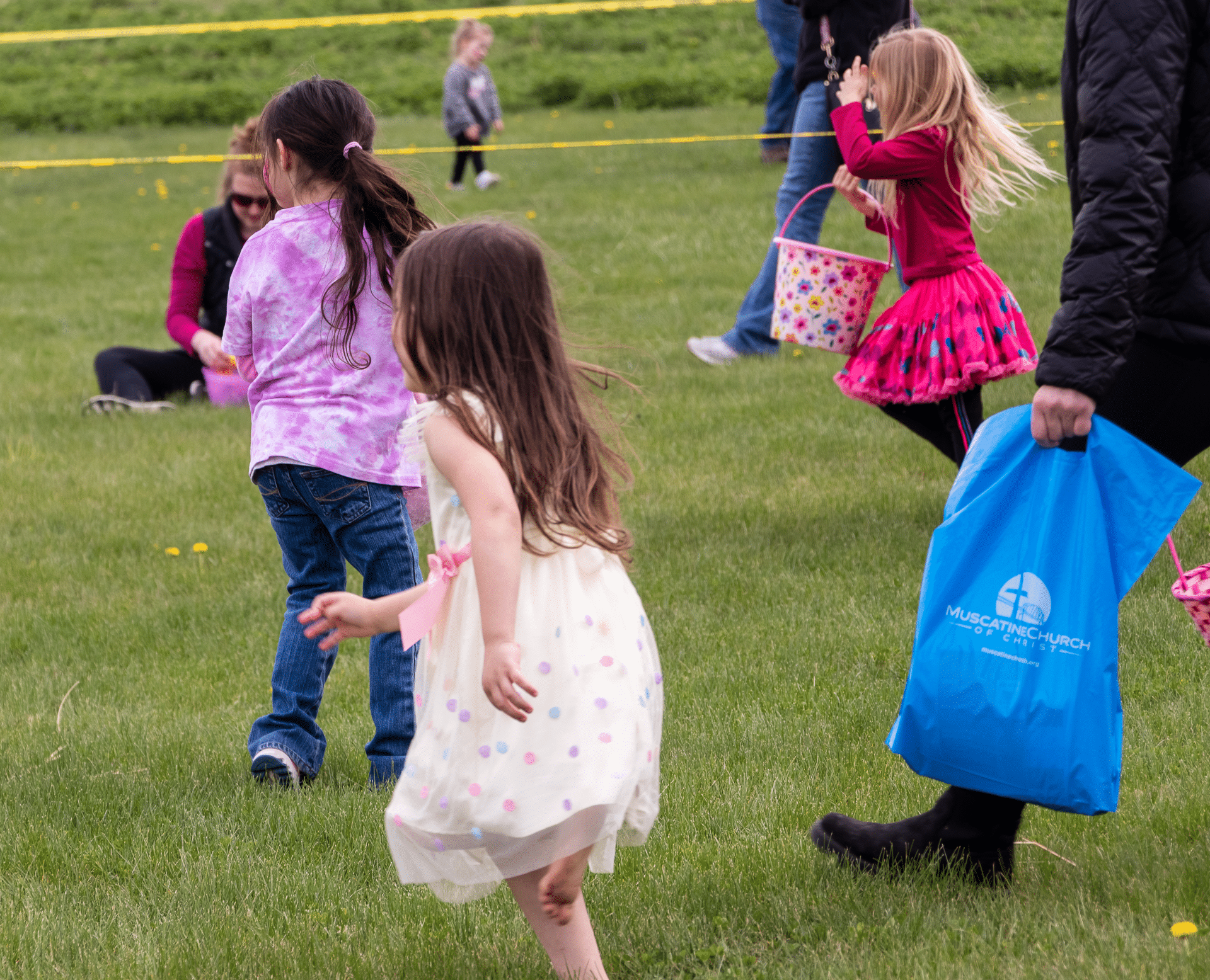 Children laugh and play together on the grass as families gather in hope, joy, and warm community. - Muscatine Church of Christ