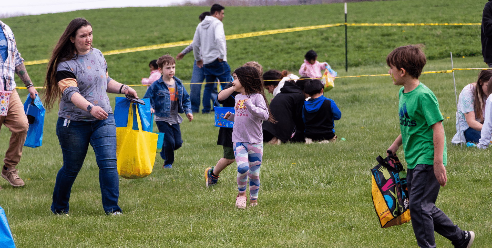 Families and friends gather on a sunny field, sharing smiles and hope at our welcoming church event. - Muscatine Church of Christ