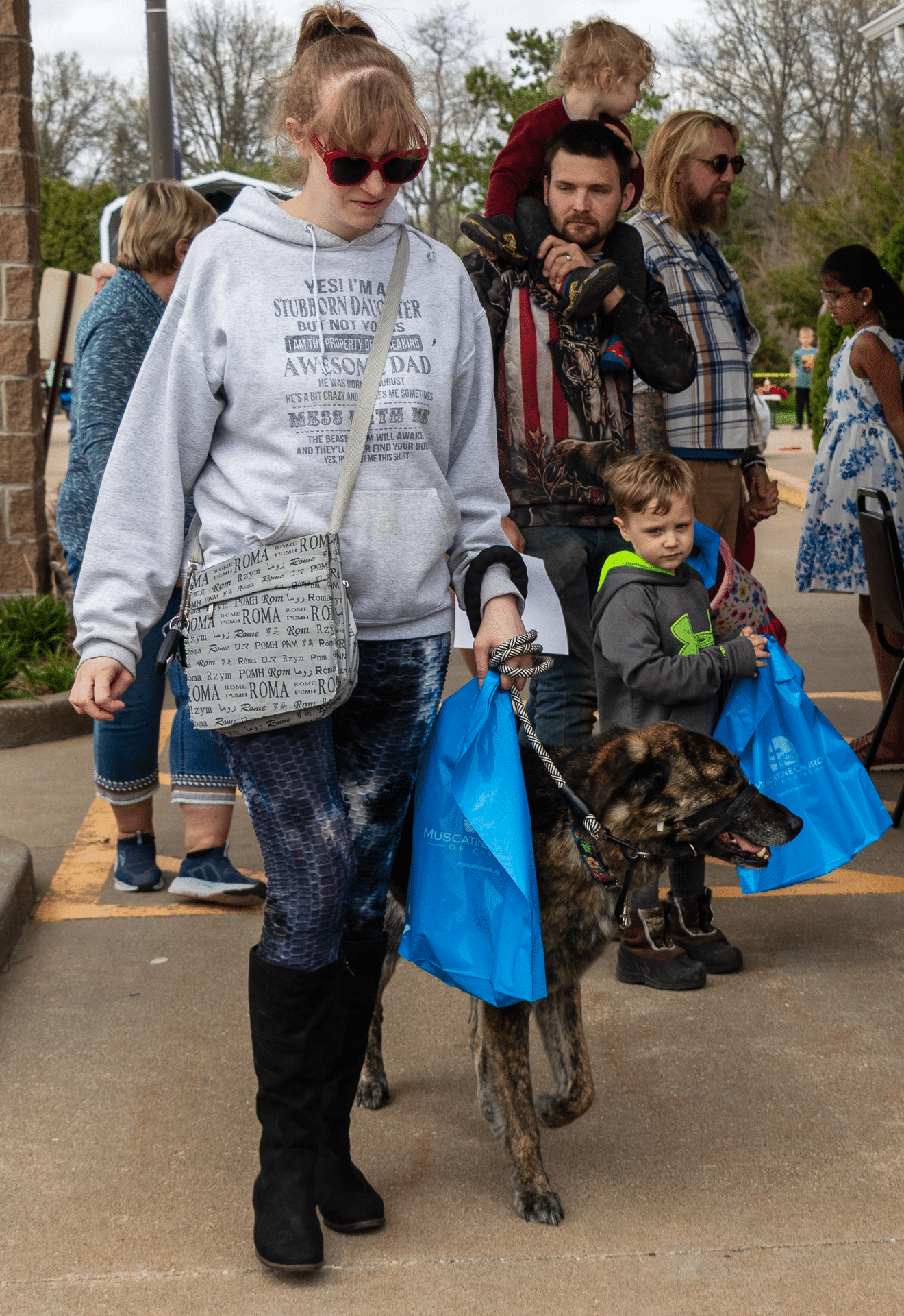A joyful woman with her dog, among friendly families outdoors—sharing hope, welcome, and community together. - Muscatine Church of Christ