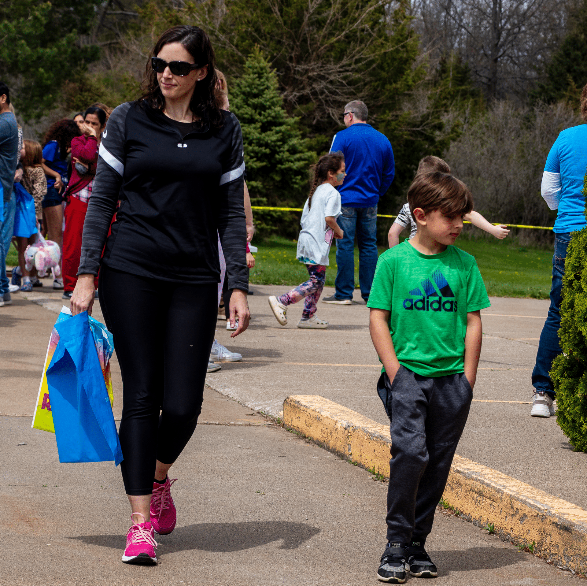 A woman and a boy walk together, smiling among friends at a joyful Muscatine Church of Christ gathering. - Muscatine Church of Christ