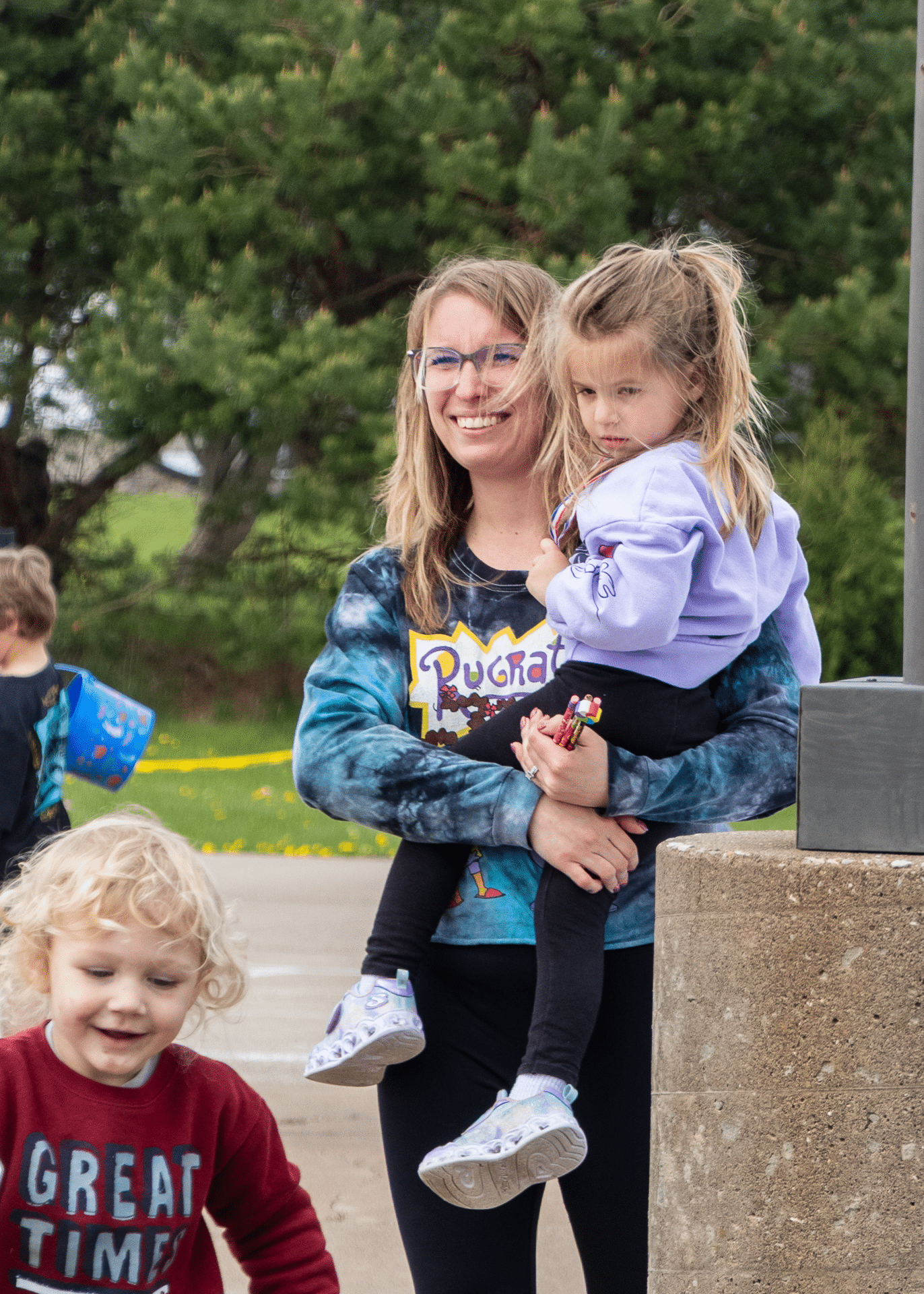 A woman and children share a joyful moment outdoors, surrounded by the warmth and hope of our church family. - Muscatine Church of Christ